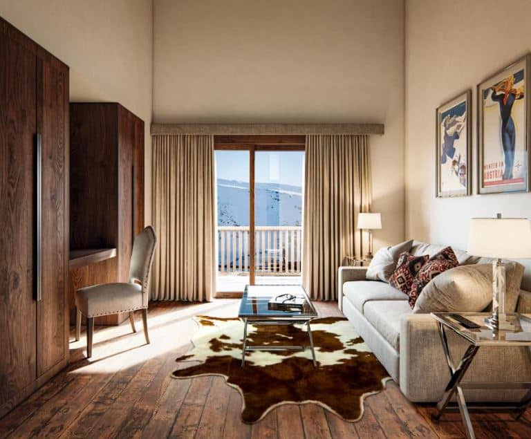 living room with sofa, desk and balcony overlooking the slope at Hotel Maribel in Sierra Nevada, Granada