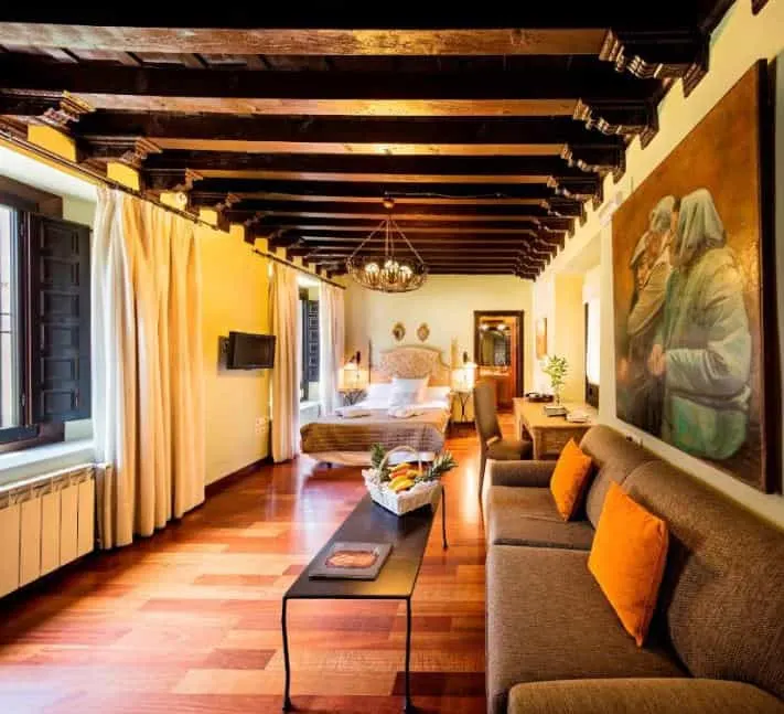 room with sofa, bed and desk at Palacio de Mariana Pineda, best 4 star hotels in Granada