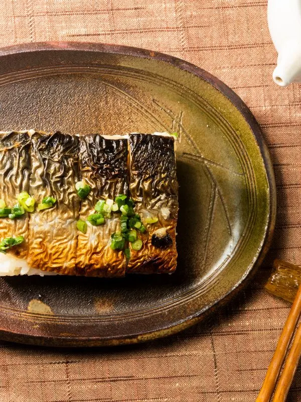 spanish mackerel sushi with grilled fish on a plate