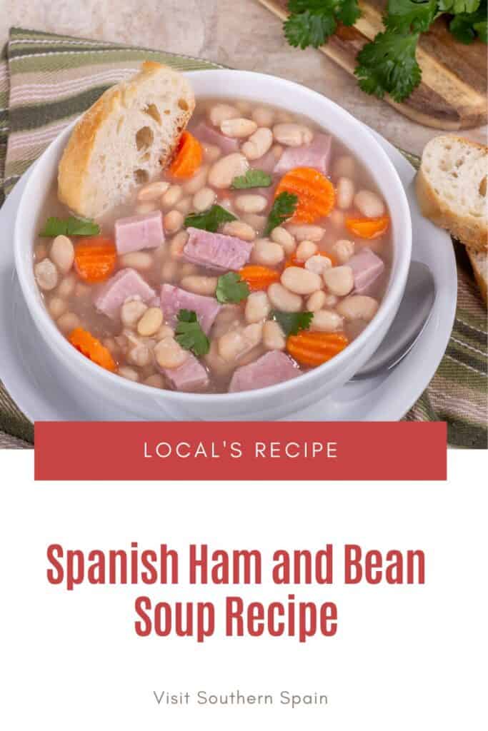 a pin with Spanish Ham and Bean Soup in a bowl with bread next to it.