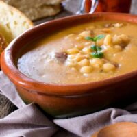 Spanish vegan bean soup served in a bowl with bread