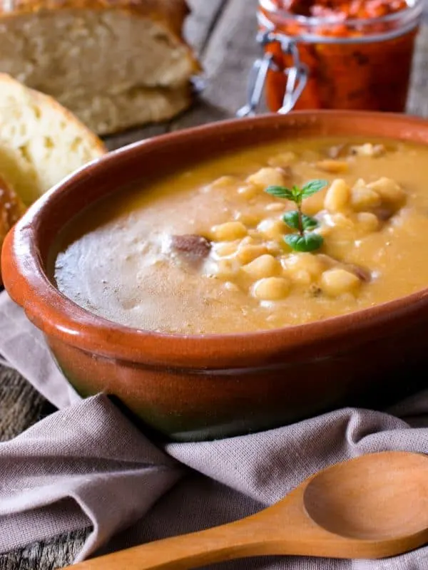 Spanish bean tomato soup served in a bowl with bread