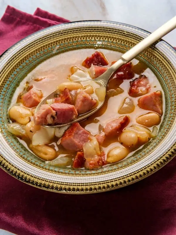 Spanish ham and bean soup served in a clay bowl