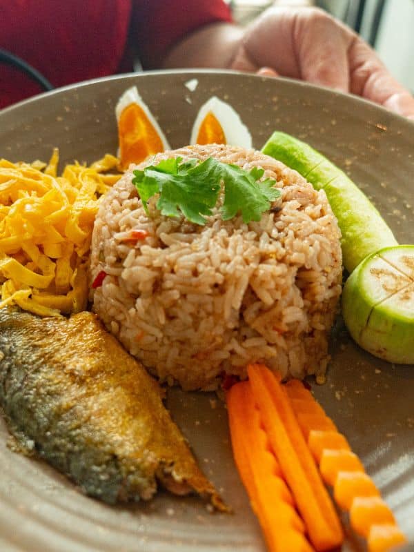 a dish of mackerel rice recipe served with fresh vegetables.
