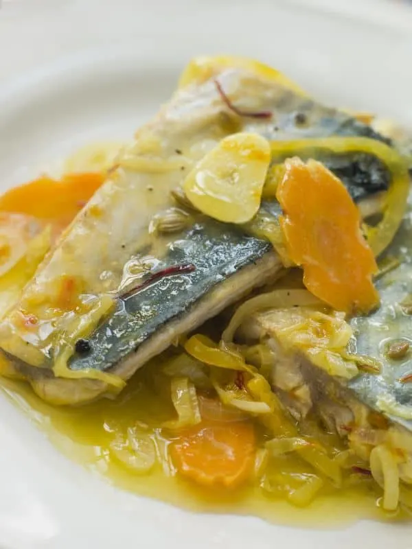 Bacalao al pil-pil with carrots and onion on a plate