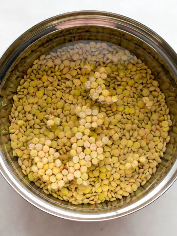 lentils being soaked in water for the Spanish lentil soup with chorizo