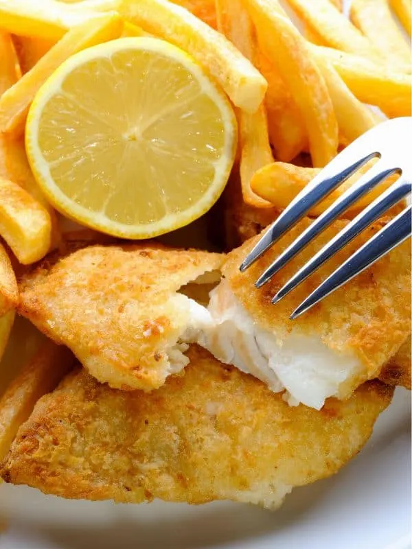 closeup of Fried Mackerel Fish Recipe served with fried and a lemon slice
