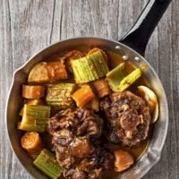 estofado de rabo de toro with vegetables in a pot