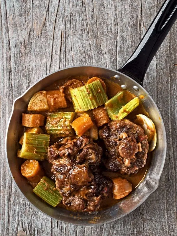 estofado de rabo de toro with vegetables in a pot