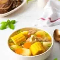 puerto rican chicken soup in a bowl with corn