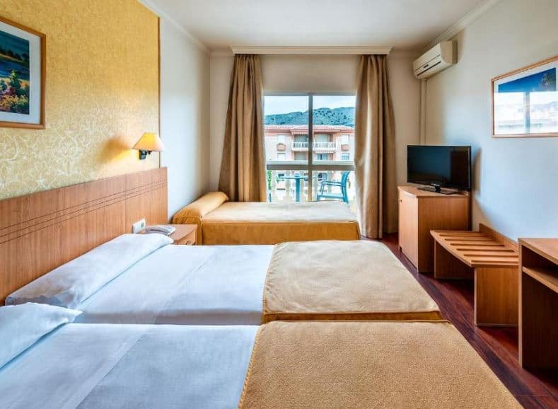room with 3 beds, TV at Hotel Santa Rosa, one of the best family resorts in Malaga