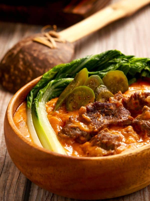 a bowl of curry oxtail recipe decorated with jalapeno