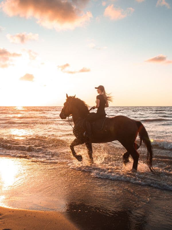 a woman riding a horse on a beach as part of the best things to do in Marbella in February