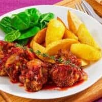 oxtail recipe with red wine served with potato wedges and salad