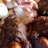 closeup of a roasted oxtail recipe served with salad
