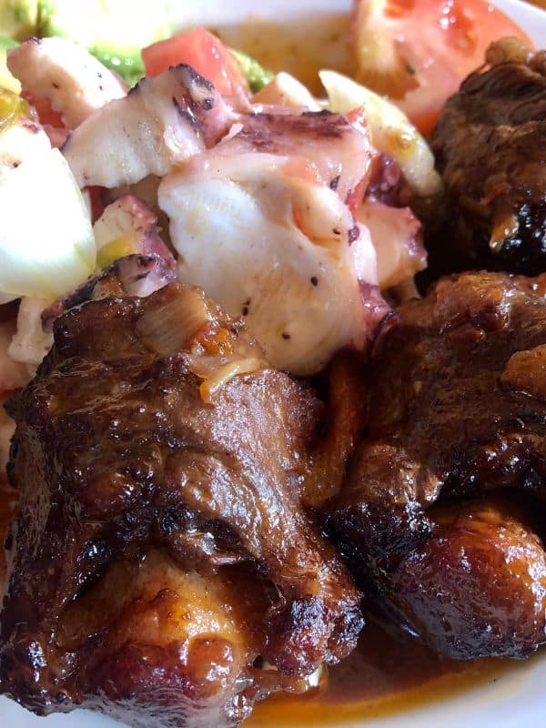 closeup of a fried oxtail recipe served with salad