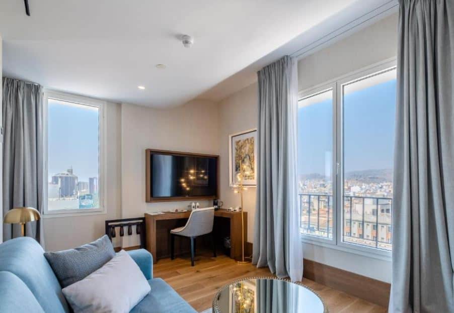 living room area with desk, TV and city view at Soho Boutique Equitativa, one of the top hotels in Malaga