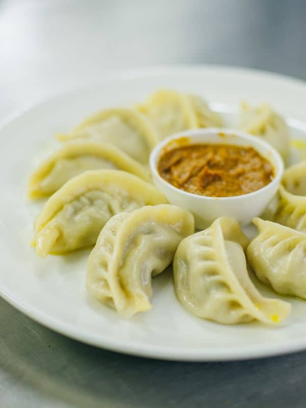 oxtail dumplings on a plate served with a red sauce