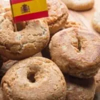 Rosquillas de Anís on a plate with a small flag of Spain on top of them