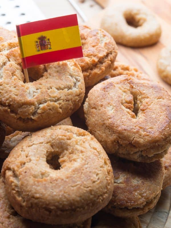 Rosquillas de Anís on a plate with a small flag of Spain on top of them