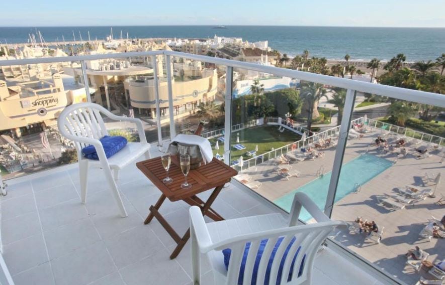 balcony with chairs and table overlooking the pool and sea at otel Alay - Adults Only Recommended in Malaga