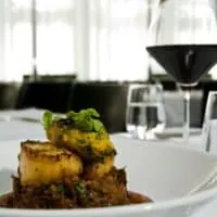 braised oxtails in oven served with potatoes and a glass of red wine