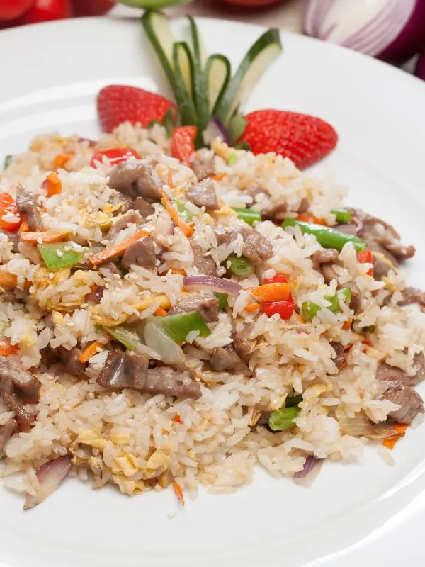 closeup of a oxtail fried rice served on a white plate