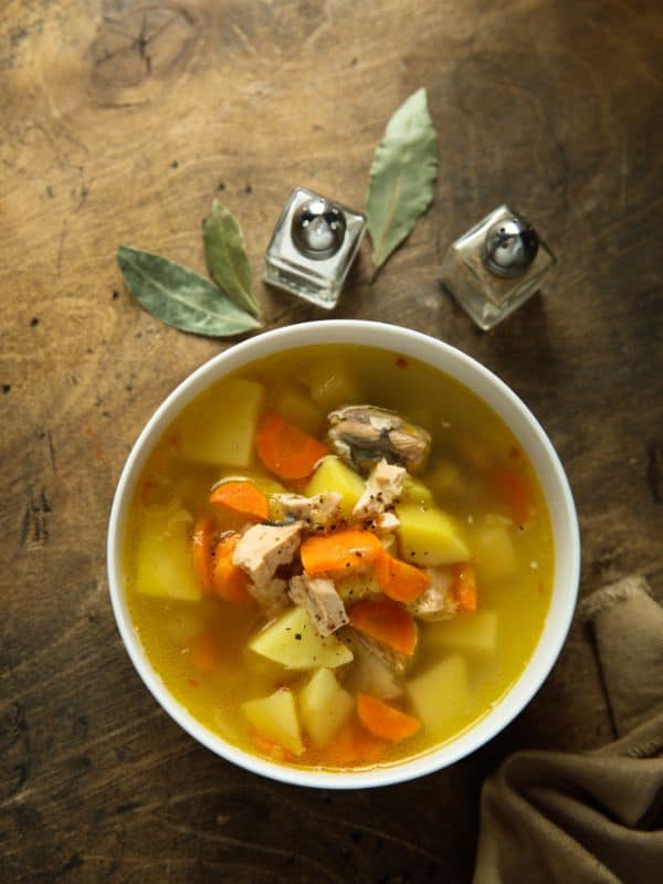 flounder soup with carrots and potatoes on a wooden table