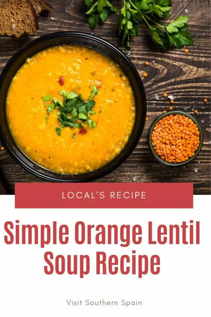 a pin with an orange lentil soup in a black bowl on a wooden surface.