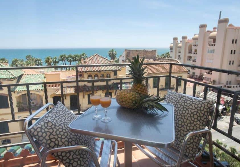 balcony with a table and chairs overlooking the sea at Soho Boutique Los Naranjos in Malaga