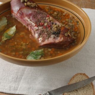 lentil soup with ham bone in a bowl served with bread