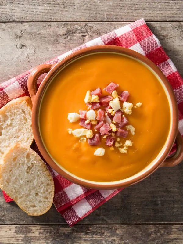 bacon tomato soup in a clay bowl served with bread