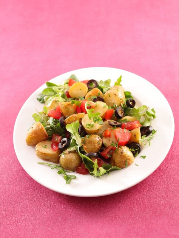 Spanish Potato Salad With Olives on a pink surface