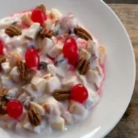 cranberry chicken pecan salad in a bowl on a wooden board.