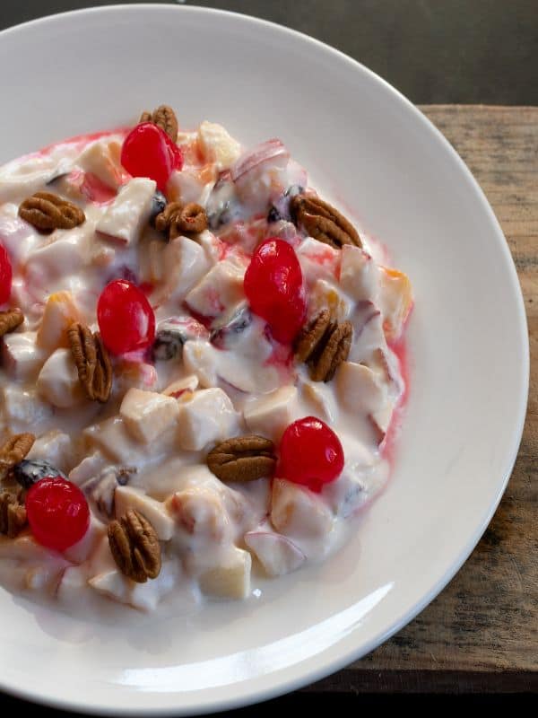 ensalada de manzana in a bowl on a wooden board.