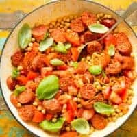 chickpea and chorizo salad in a bowl on a wooden surface