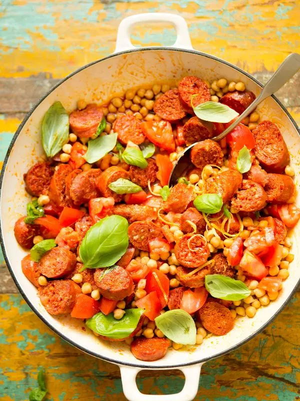 chickpea and chorizo salad in a bowl on a wooden surface