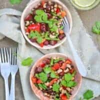 hot bean salad in 2 bowl on a table cloth