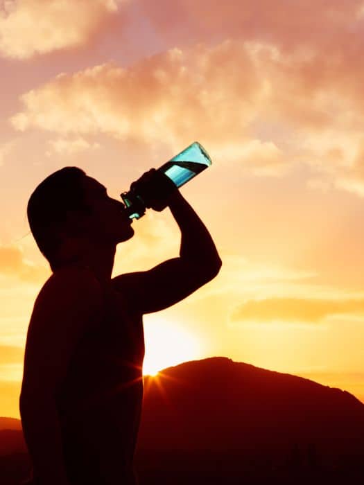 man drinking water with the sun doing down in Andalucia in August