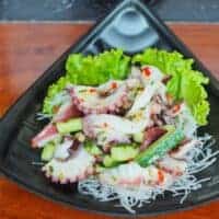 tako salad recipe in a black bowl on a wooden surface