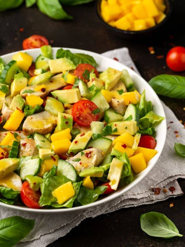 Chicken Mango Salad with avocado, tomatoes in a bowl