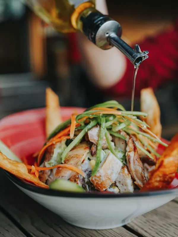 chicken mango salad in a bowl with olive oil