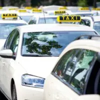 many taxis are lined up on the side of the road