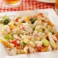 chicken broccoli salad on a plate served with a glass of beer