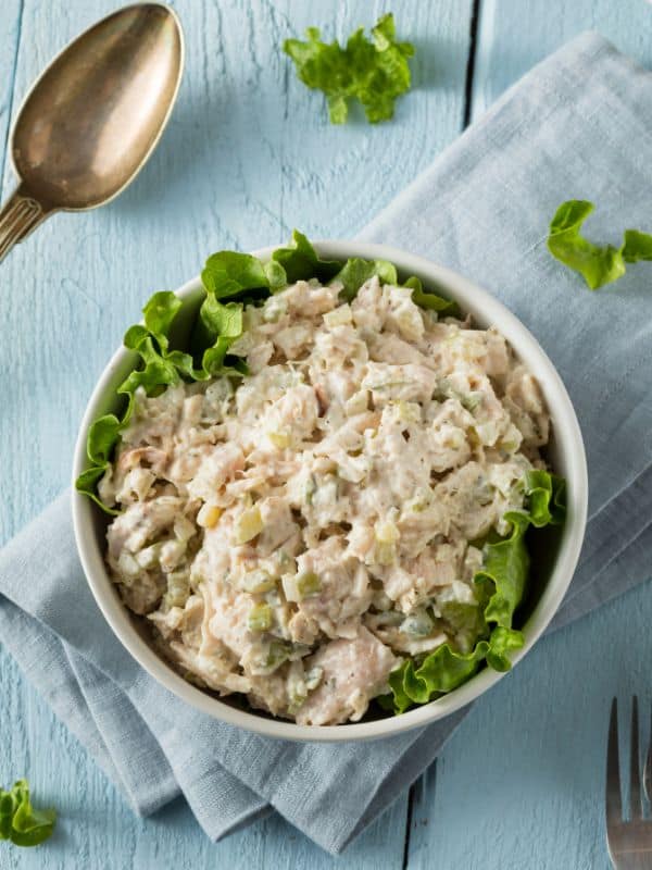 chicken salad recipe with yogurt in a bowl on a blue table