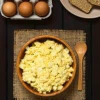 spanish egg salad in a clay bowl with eggs and toast next to it.