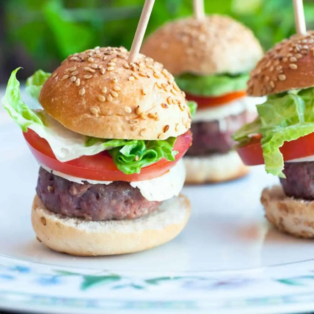 small hamburgers on a plate with toothpicks