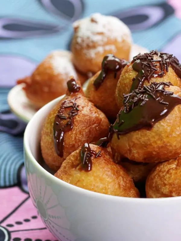 churros balls recipe in a bowl topped with chocolate