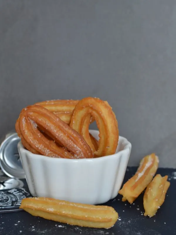 spanish dessert churros in a white bowl 