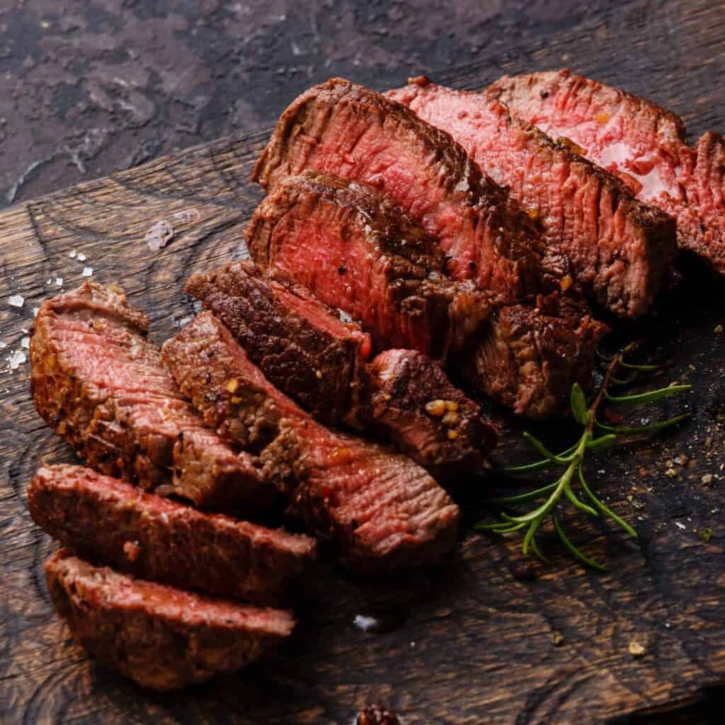 sliced beef steak on a wooden cutting board